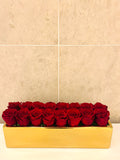 SIXTEEN PRESERVED ROSES IN RECTANGULAR VASE