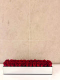 TWENTY FOUR PRESERVED ROSES IN RECTANGULAR MIRRORED VASE